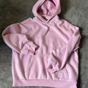 Ljusrosa hoodie från Urban Classics - Säljer en ljusrosa hoodie från Urban Classics i storlek L. Tröjan har huva, magficka och ribbade muddar vid ärmslut och nederkant. Perfekt för chill dagar och enkel att matcha med jeans eller joggers.