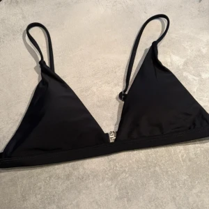 Bikini överdel  - Snygg svart trekantsbikini med smala, justerbara axelband och metallspänne i ryggen.