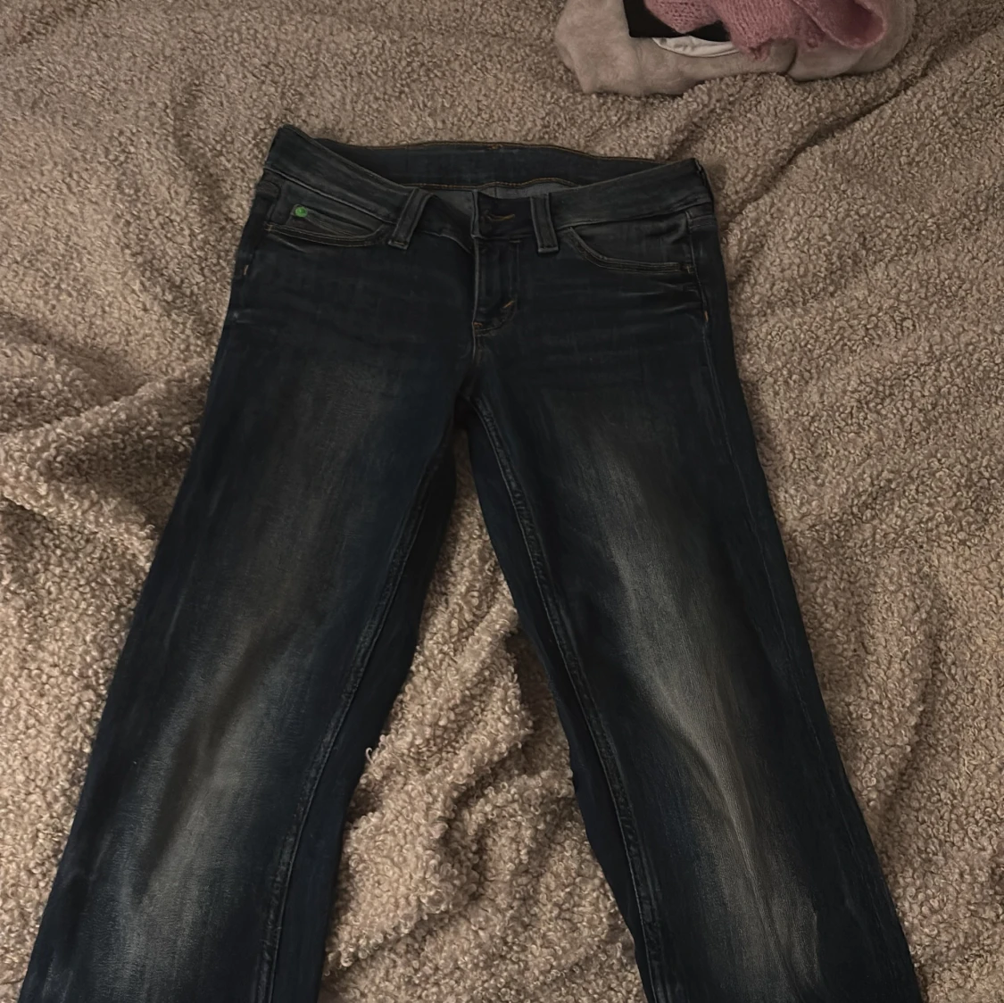 Mörkblå bootcut jeans med grönt märke
