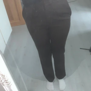 Bruna kostymbyxor  - Snygga bruna kostymbyxor från Dilvin Basic med rak passform och hög midja. Byxorna har klassisk look med diskreta fickor och är tillverkade i ett mjukt, vävt material som känns bekvämt hela dagen. 