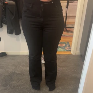 Svarta flare jeans från Bershka - Snygga svarta jeans från Bershka i flare modell med typ hög midja. Jeansen har klassisk femficksdesign, dragkedja och knapp framtill. Materialet är mjukt och stretchigt för en bekväm passform. Perfekta för dig som vill ha en stilren och trendig look. Säljer dessa eftersom jag ångra mig och dom är helt nya, bara bärd 2 gånger.