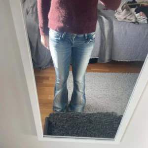 Gina 14+ jeans - Snygga blå bootcut jeans från Gina Tricot med slitna detaljer och ljusa tvättade partier. Klassisk femficksmodell, låg midja och stretchigt jeanstyg som sitter skönt. Perfekta för dig som gillar en retro vibe och vill ha ett par jeans som sticker ut. Storlek xs lite långa på mig som är 165. Knappt använda