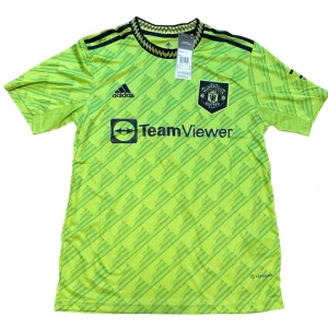 Manchester United Ronaldo 7 bortatröja - Snygg Manchester United bortatröja från Adidas med Ronaldo 7 på ryggen. Tröjan är ljusgrön med grafiskt mönster, svarta detaljer och klubbmärke på bröstet. Tillverkad i lätt och ventilerande polyester, perfekt för fotbollsplanen eller att bära som supporter.