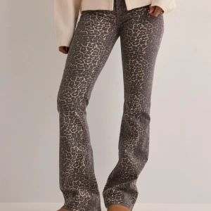 Leopardmönstrade bootcut jeans - Snygga jeans med leopardmönster i mörka och beige toner. Byxorna har bootcut-snitt och sitter tajt upptill med utsvängda ben. Perfekta för dig som vill sticka ut med en cool och trendig look.