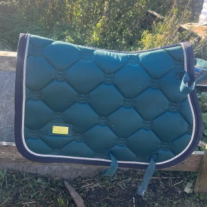 Mörkgrön schabrak Equestrian Stockholm st ponny  - Snyggt mörkgrönt schabrak från Equestrian Stockholm storlek ponny. 450kr + frakt. Det tvättas innan så all päls försvinner. 