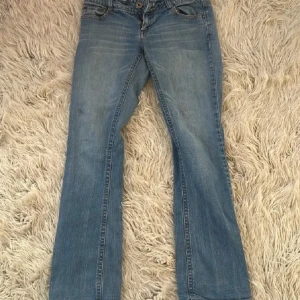 Blå bootcut jeans från ONLY - Snygga ljusblå jeans från ONLY i klassisk bootcut-modell. Jeansen har normal passform, fem fickor och dragkedja med knapp framtill. Tillverkade i slitstarkt denim med snygga slitningar och kontrastsömmar. Perfekta för dig som gillar en avslappnad och trendig look.