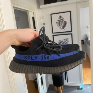 Adidas Yeezy Boost 350 V2 Black/Blue - Säljer ett par Adidas Yeezy Boost 350 V2 med svart Primeknit-överdel och en blå rand.                          Storlek 43