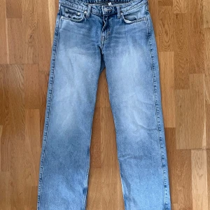 Arrow low, weekday  - Ljusblå tvätt med raka ben och lågmidjade. Jeansen har en snygg vintagekänsla, knappgylf och läderpatch bak i midjan. Perfekta för en avslappnad och tidlös stil. Storlek: 26/32 weekday 