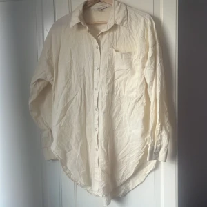 Vit skjorta från Esprit, strl 38 - Klassisk vit skjorta från Esprit i storlek 38. Skjortan har lång ärm, bröstficka och knappar framtill. Tillverkad i mjuk bomull och har en avslappnad passform med rundad nederkant. Perfekt att styla lager på lager eller bära som den är.