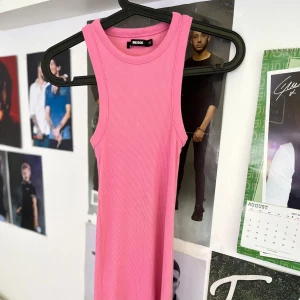 Rosa ribbad klänning från Bik Bok - Säljer en rosa ribbad långklänning från Bik Bok i storlek XS. Klänningen är ärmlös med breda axelband och har en tight passform. Perfekt för dig som gillar en enkel men snygg look. Materialet är stretchigt och bekvämt.