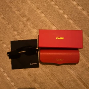 Solglasögon  - PRIS KAN DISKUTERAS!! Snygga svarta solglasögon med rektangulära linser och gulddetaljer på bågarna. Kommer med originalröd ask, fodral och putsduk. Perfekt accessoar för dig som vill sticka ut med lyxig stil.