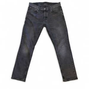 Nudie jeans  - Grå/Svarta Nudie jeans I modellen Grim Tim. L30/75cm W33/88cm Hela längden på byxan:105cm Tyget är lite ruffsigt på ena fram fickan men inget man märker. Annars är allt som det ska vara.