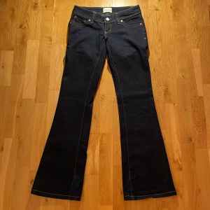 Low Waist Bootcut Jeans från Abrand - Mörkblå jeans från Abrand med low waist och bootcut.                    Midjemått rakt över är: 35cm och innerbenslängden är: 83cm. Skriv gärna för mer bilder eller info om jeansen💕