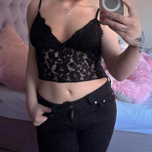 Svarta bootcut jeans från Gina! - Snygga svarta jeans från Gina tricot med bootcut passform och klassisk femficksdesign. Jeansen har låg midja och är tillverkade i stretchig bomullsblandning för en bekväm känsla. Bakfickorna har lock och knappdetalj som ger extra stilpoäng.