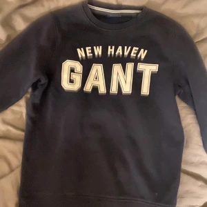 Mörkblå sweatshirt från GANT XS - Snygg mörkblå sweatshirt från GANT i storlek XS med trycket 'NEW HAVEN GANT' framtill. Klassisk rund halsringning och ribbade muddar. Perfekt för en chill och sportig look.