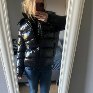 Svart Moncler pufferjacka - Säljer en svart, glansig pufferjacka från Moncler. Skulle säga att den är i Storlek S. Priset då de är en lite äldre men även att jag vill bli av med den fort. Pris kan diskuteras!❤️