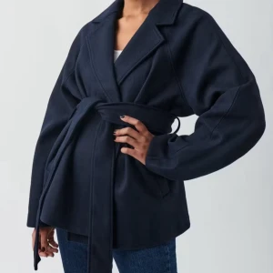 Marinblå kappa  - Snygg marinblå kappa med bred krage och knytbälte i midjan. Jackan har en loose passform och långa ärmar, perfekt för att ge en chill och stilren vibe till din outfit. Passsr xs-s. Lite nopprig men sparsamt använd. 