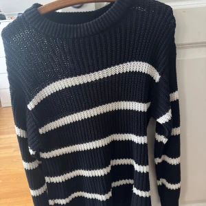 2 stickade tröjor  - Två snygga stickade tröjor från lager 157, en svart med vita ränder i storlek S och en vit med svarta ränder i storlek M. Båda har rund hals, grov ribbstickning och lång ärm. Perfekt för dig som gillar klassisk stil med en modern twist.