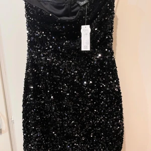 Ny klänning strl XS  - Helt ny glittrig klänning i strl XS från Lindex. Dold dragkedja i ryggen. Tyget är lite stretchigt. Prislapp kvar. Nypris: 499kr. 