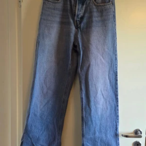 Blå raka jeans med hög midja - Klassiska blå jeans med hög midja och raka ben. Perfekta för en avslappnad och trendig look. Materialet är robust denim i bomull. Knappt använda. 