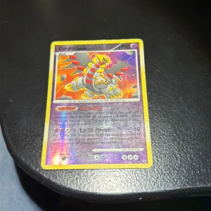 Giratina - Cool Giratina Pokémon-kort med glittrande effekt! Perfekt för dig som samlar eller spelar Pokémon TCG. Kortet har unika attacker och är ett måste för alla fans som vill ha något extra i sin samling.