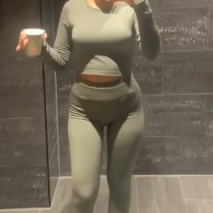 Olivgröna tighta leggings plus topp - Säljer ett par olivgröna leggings med hög midja och tight passform. Perfekta för dig som gillar en sportig och bekväm stil. Materialet är stretchigt och följsamt, vilket gör dem sköna att bära hela dagen.