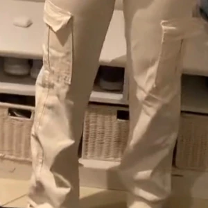 Beiga cargopants med fickor - Snygga beiga cargopants med hög midja och stora fickor på sidorna. Byxorna har raka ben och klassisk knappstängning framtill. Perfekta för dig som gillar streetstyle och vill ha en cool look. Materialet känns slitstarkt och bekvämt.