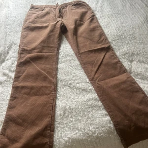 Bruna manchesterbyxor från Stay - Snygga bruna manchesterbyxor från Stay i klassisk rak modell. Byxorna har fem fickor, dragkedja och knapp med Stay-logga. Mjukt manchestertyg som ger en chill och retro vibe. Perfekta för dig som gillar en avslappnad men ändå stilren look.