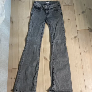 Grå bootcut jeans från Nelly -  Snygga jeans från Nellie i storlek 34. Knappt använda använd ungefär tre gånger men fått slitningar där nere på jeansen men inget som syns🩷