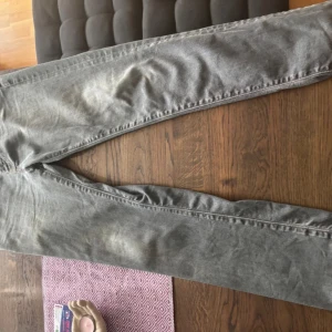 Levis 511 grå jeans straight fit - Säljer ett par Levis 511 jeans i grå tvätt med klassisk femficksdesign och raka ben. Jeansen har normal passform och är tillverkade i mjukt jeanstyg. Perfekta för dig som gillar en clean och enkel look med lite slitning för extra edge.