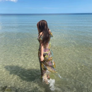 Blommig offshoulder långklänning XS - Superfin långklänning från The Perfect i storlek XS. Klänningen har offshoulder-modell, volangdetaljer och ett färgstarkt blommigt mönster i blått, grönt, gult och orange. Tunt, lätt material som känns luftigt och perfekt för varma dagar.