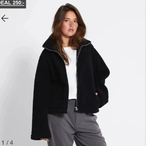 Svart teddyjacka med dragkedja - Säljer en svart teddyjacka med hög krage och dragkedja framtill. Jackan har en loose passform och är tillverkad i mjukt teddy-material som ger en chill och trendig look. Perfekt för lager-på-lager och funkar till de flesta outfits.