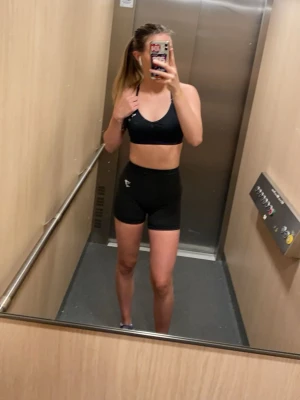 Svarta träningsshorts från Gymshark - Säljer ett par svarta seamless träningsshorts från Gymshark med hög midja och diskret logga på låret. Shortsen är stretchiga och har ventilerande mesh-detaljer som gör dem perfekta för gymmet eller löpning.