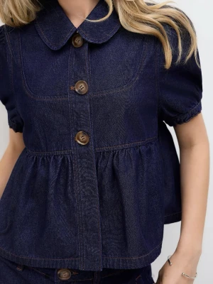 Mörkblå denimskjorta med puffärm - Säljer en mörkblå skjorta i denim med korta puffärmar och stora bruna knappar framtill. Skjortan har en bred krage och rynkad midja som ger en cool och avslappnad siluett. Perfekt att styla med jeans eller shorts för en trendig look.