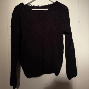 Svart stickad tröja  - Mysig svart stickad tröja från lager 157 med grov struktur och rund hals. Tröjan har långärmade ärmar och en loose passform som gör den extra skön att bära. Perfekt för kyliga dagar och enkel att matcha .