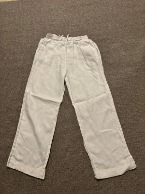 Vita linnebyxor me - Säljer ett par vita linnebyxor från Cubus i storlek M. Byxorna har rak passform, resår och snörning i midjan för extra komfort. Materialet är linne, vilket gör dem luftiga och sköna. Perfekta för varma dagar och chill stunder. Som man kan se på sista bilden har den en liten fläck syns knappt kan knappt se den med egna ögon 