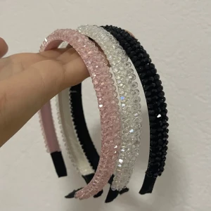 Glittriga hårdiadem i rosa, vit och svart (FRI FRAKT TILL 5/1)‼️ - Tre snygga hårdiadem med glittriga pärlor i färgerna ljusrosa, vit och svart. Diademen har en rundad form och är täckta med små fasetterade pärlor som ger ett riktigt coolt och glittrigt intryck. Perfekt för att lyfta din look med lite extra bling.