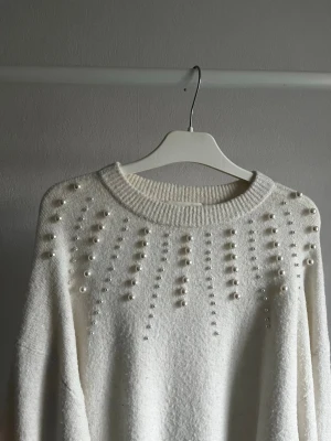 Stickad tröja med pärlor - Vit stickad tröja med pärlor från HM, storlek XS. Lite nopprig men går nog att dra bort dem.