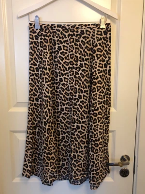 Leopardmönstrad långkjol - Säljer en snygg långkjol med leopardmönster i beige och svart. Kjolen är i viscose.  
