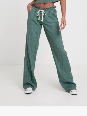 Gröna linnebyxor från Roxy med snörning - Snygga gröna linnebyxor från Roxy med breda ben och hög midja. Byxorna har vit snörning i midjan, elastisk linning och fickor fram och bak. Perfekt för chill dagar och har en cool, loose passform. Roxy-logga broderad på bakfickan.