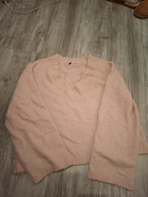 Ljusrosa stickad v-ringad tröja -  Ljusrosa stickad tröja från H&M med v-ringning och ribbade detaljer vid hals, ärmslut och nederkant. Materialet är tunnt men mjukt. Nytt/ Fint skick, Aldrig använt. Storlek M med loosefit. Köpt för 200kr, priset kan förhandlas!