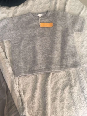 Grå stickad tröja - Säljer en ny stickad tröja från Gina , aldrig använd 