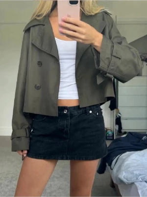 Croppad mörkgrön trenchcoat - Snygg croppad trenchcoat i mörkgrönt. Storlek xs och endast använd 1-2 gpnger därav näst intill nyskick. 