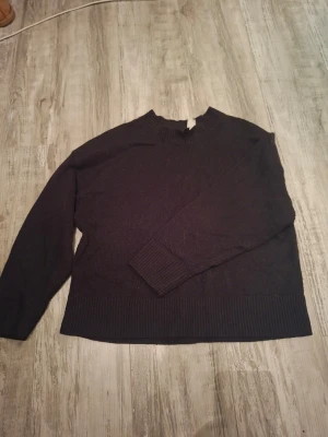 Svart stickad tröja med ribbad kant - En svart stickad tröja från H&M (divided) med rund hals och ribbade muddar vid ärmslut och nederkant. Tröjan har en loosefit och slutar ungefär vid midjan på mig (174cm). Används flera gånger men är i gott skick. Storlek S. Vet ej vad jag köpte för, priset kan förhandlas!