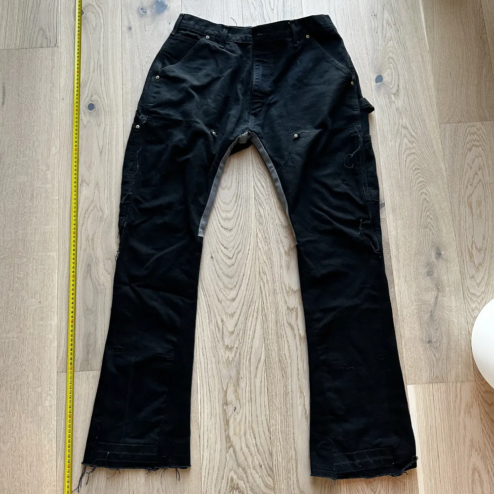 Reworked Carhartt Doubleknee med flare och extra grå detals vid insida lår. Storlek W30 L32. Mörk blå svart färg. Jeans & Byxor.