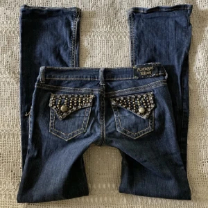 Jeans  - Säljer vidare dessa mörkblåa lowrise bootcut jeans från Antique Rivet!💗Midja 39cm tvärsöver, innerbenslängd  79 cm. Jag är 169 cm.  LÅNADE BILDER !!