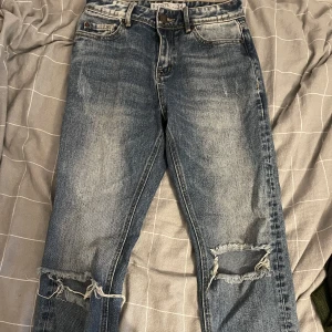 Jeans med hål - Coola fadeade jeans! Köpte på New yorker och är i bra skick🌟 har lite röda och gula detaljer längst ner och har hål vid knäna💞säljer då de är för korta på mig och inte kommer till användning   Vid frågor besvarar jag dom jätte gärna privat💘