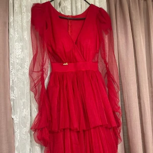 En röd klänning  - Välvårdad klänning använd 2 gånger bara skicket är som ny. 