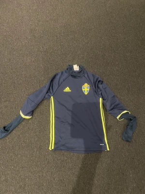 Adidas Sverige träningströja  - Snygg träningströja perfekt när det är lite kallare. I tränings tröjan finns det så man kan ha som handskar nästan
