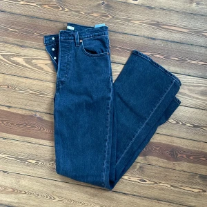 Levis  - Säljer ett par mörkgrå, ganska kraftiga Levis jeans i modellen ribcage boot i storlek 28!